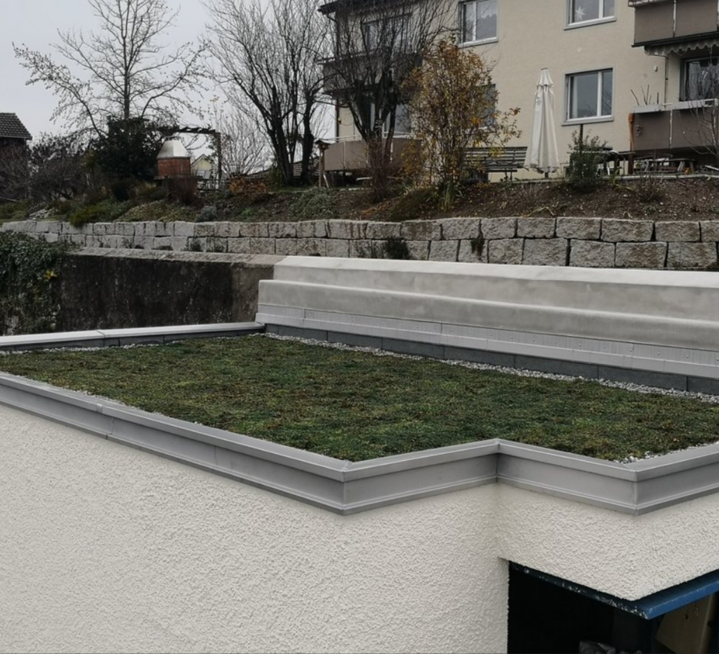 Begrüntes Flachdach mit grauem Randabschluss